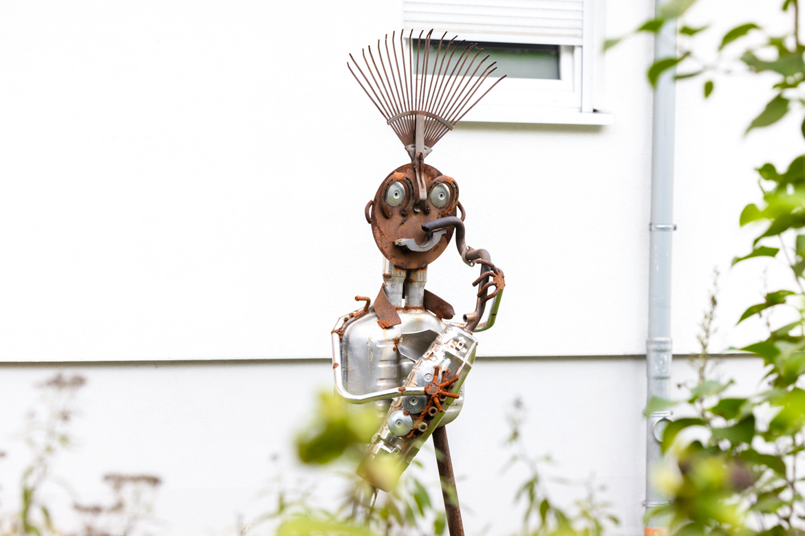 Eine künstlerische Statue aus verschiednen metallischen Objekten. 