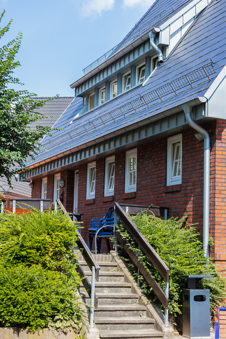 Treppe zum Hauseingang eines Backsteinhauses. 